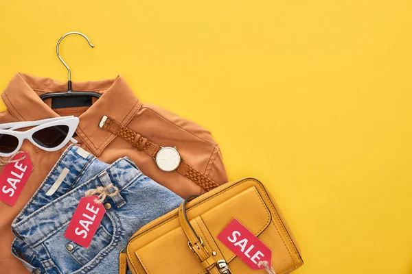 Vue du haut du sac, chemise, lunettes et jeans isolés sur jaune — Photo de stock