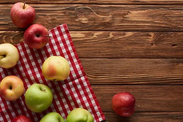 Top view of checkered tablecloth with fresh apples on wooden surface with copy space — Stock Photo