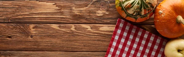 Panoramic shot of checkered tablecloth with ripe apples and pumpkins on wooden surface with copy space — Stock Photo