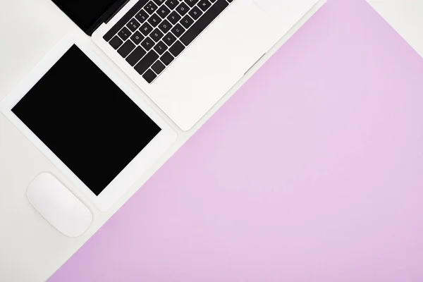 Flat lay com laptop, tablet digital com tela em branco e mouse no fundo violeta e branco — Fotografia de Stock