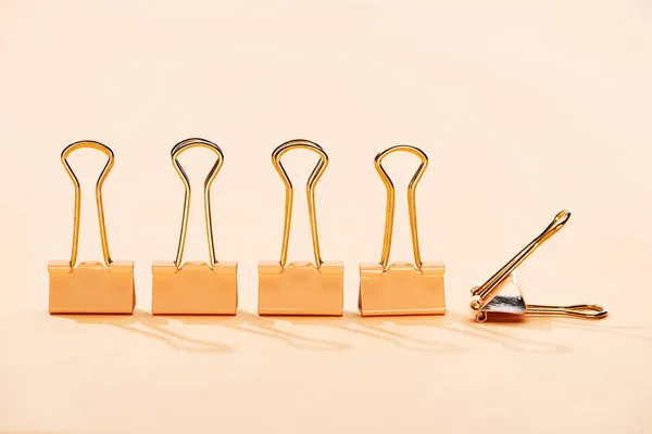 Row of paper clips on beige background with copy space — Stock Photo