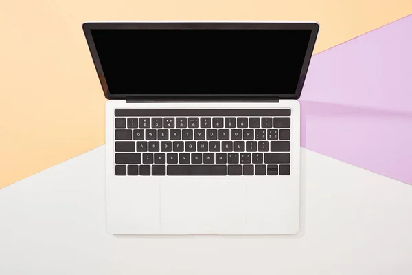 Top view of laptop with blank screen on beige, violet and white background — Stock Photo