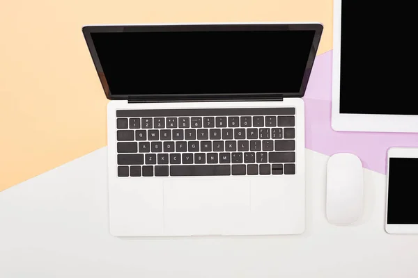 Flat lay with laptop, digital tablet, smartphone with blank screen and computer mouse on beige, violet and white background — Stock Photo