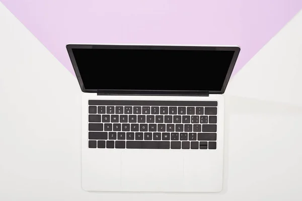 Вид зверху на ноутбук з порожнім екраном на фіолетовому та білому тлі — стокове фото