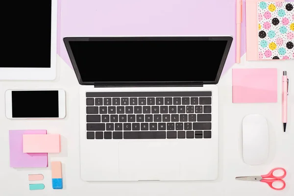 Flat lay com laptop, tablet digital, smartphone com tela em branco, material de escritório e mouse de computador em fundo violeta e branco — Fotografia de Stock