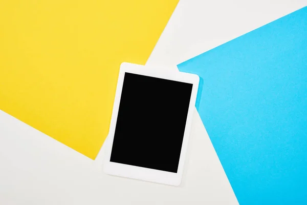 Top view of digital tablet with blank screen on yellow, blue and white background — Stock Photo