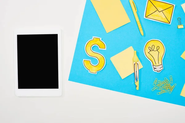 Ansicht des Arbeitsplatzes mit Bürobedarf, Papiersymbolen und digitalem Tablet auf blauem und weißem Hintergrund — Stockfoto