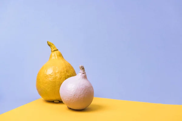 Painted pumpkins on violet and yellow background — Stock Photo