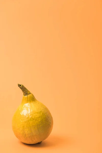 Пофарбований жовтий гарбуз на помаранчевому барвистому фоні — стокове фото