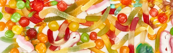 Vista de cerca de deliciosos dulces de Halloween espeluznantes gomosos coloridos, tiro panorámico - foto de stock