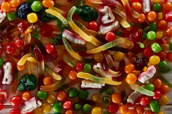 Vista superior de deliciosos dulces de Halloween espeluznantes gomosos coloridos - foto de stock