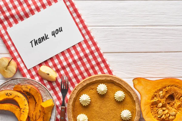 Top view of pumpkin pie with thank you card on wooden white table with apples — Stock Photo