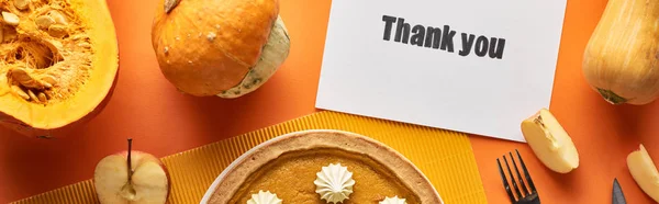 Top view of pumpkin pie with thank you card on orange background with apples, panoramic shot — Stock Photo