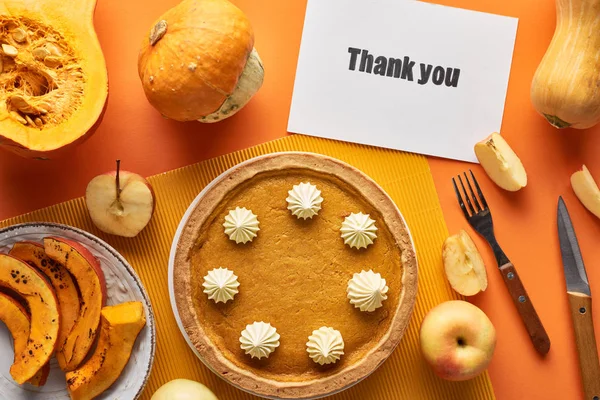 Top view of delicious pumpkin pie with thank you card on orange background with apples — Stock Photo
