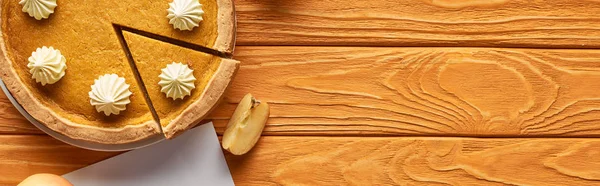 Top view of pumpkin pie with apples on wooden table, panoramic shot — Stock Photo