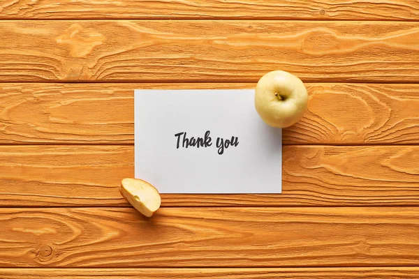 Vista superior de maçãs e cartão de agradecimento na mesa laranja de madeira — Fotografia de Stock