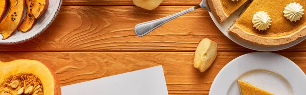 Vue de dessus de délicieuse tarte à la citrouille, pommes sur table en bois orange, vue panoramique — Photo de stock