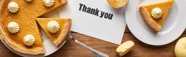 Top view of tasty pumpkin pie, apples and thank you card on wooden rustic table, panoramic shot — Stock Photo