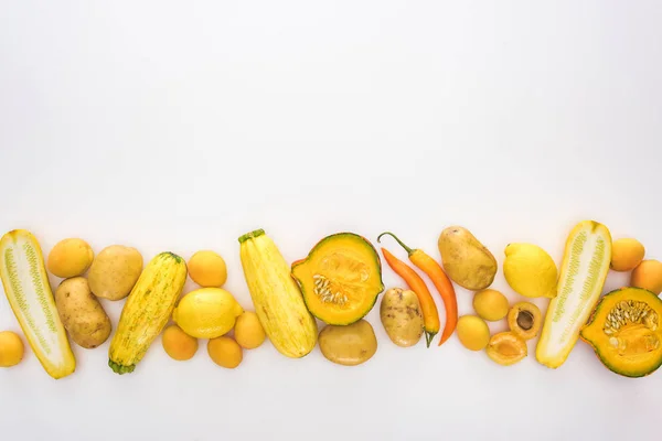Vue de dessus des fruits et légumes jaunes sur fond blanc — Photo de stock