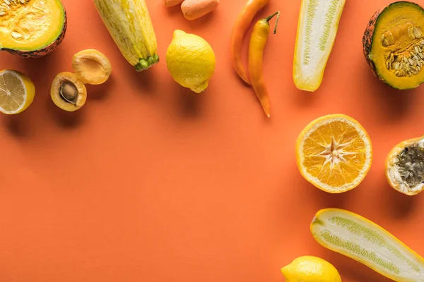 Vista superior de frutas y verduras amarillas sobre fondo naranja con espacio para copiar - foto de stock