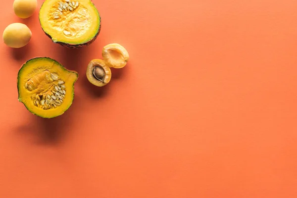 Top view of yellow apricot and pumpkin on orange background with copy space — Stock Photo