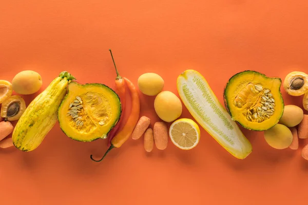 Vue du dessus des fruits et légumes jaunes sur fond orange — Photo de stock