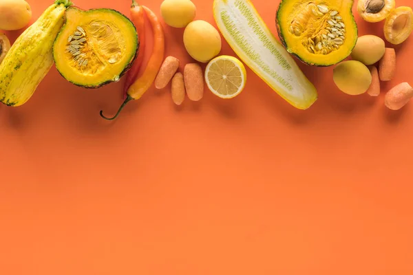 Vista superior de frutas y verduras amarillas sobre fondo naranja con espacio para copiar - foto de stock