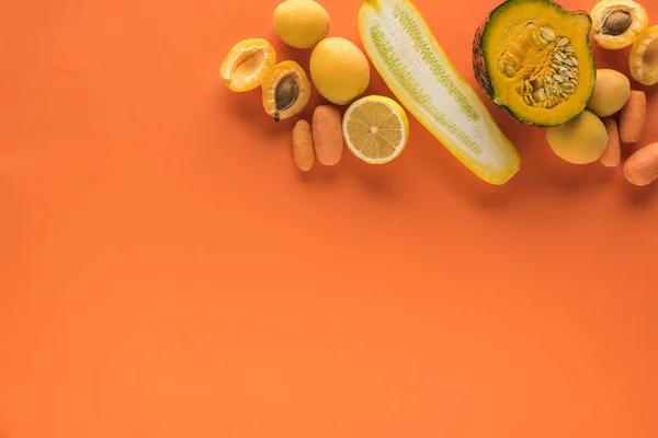 Vista superior de frutas y verduras amarillas sobre fondo naranja con espacio para copiar - foto de stock