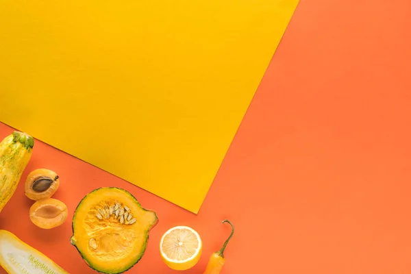 Draufsicht auf köstliches Obst und Gemüse auf gelbem und orangefarbenem Hintergrund mit Kopierfläche — Stockfoto