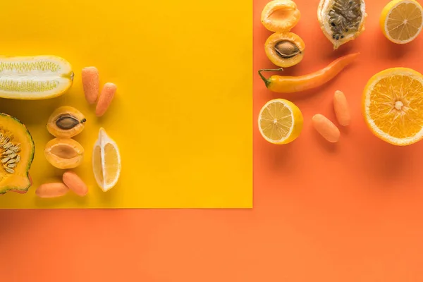 Vista superior de deliciosas frutas y verduras sobre fondo amarillo y naranja con espacio para copiar - foto de stock