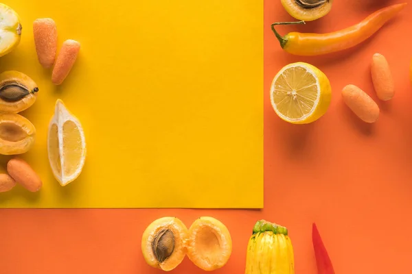 Draufsicht auf köstliches Obst und Gemüse auf gelbem und orangefarbenem Hintergrund mit Kopierfläche — Stockfoto