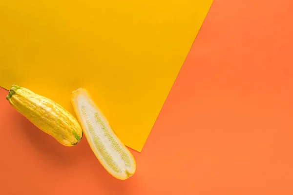Vista superior da abobrinha no fundo amarelo e laranja com espaço de cópia — Fotografia de Stock