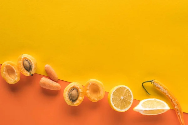 Vue de dessus des fruits et légumes frais sur fond jaune et orange avec espace de copie — Photo de stock