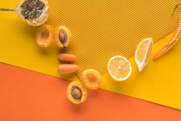 Vista superior de frutas y verduras frescas sobre fondo amarillo y naranja con espacio para copiar - foto de stock
