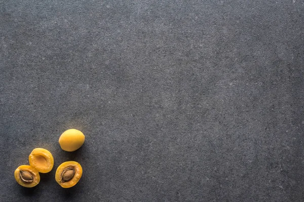 Top view of yellow apricots on grey textured background with copy space — Stock Photo