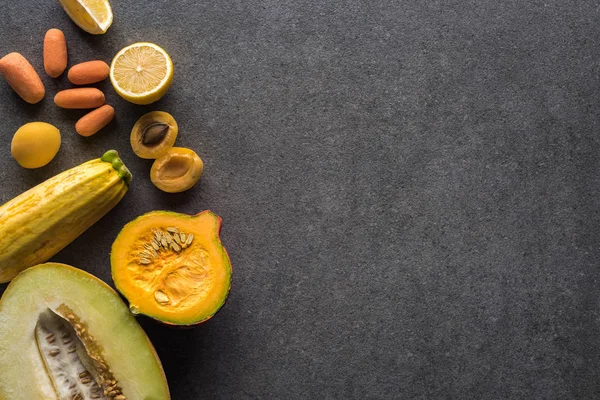 Top view of yellow fruits and vegetables on grey textured background with copy space — Stock Photo