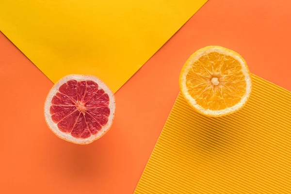 Vista dall'alto di arancio e pompelmo su sfondo giallo e arancio con spazio di copia — Foto stock