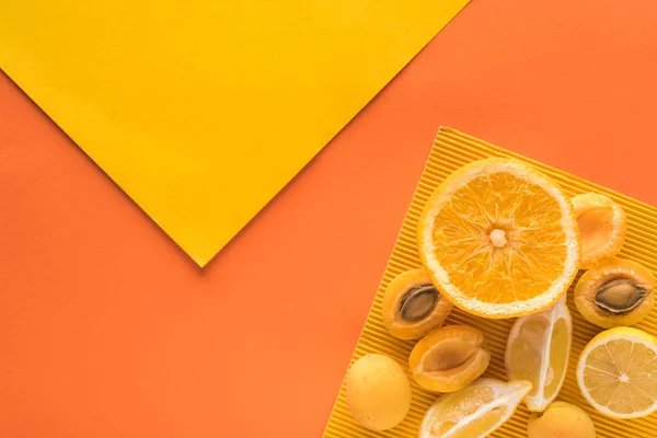 Top view of yellow fruits on yellow and orange background with copy space — Stock Photo