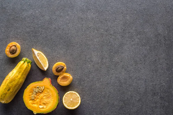 Top view of yellow fruits and vegetables on grey textured background with copy space — Stock Photo