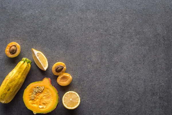 Vista superior de frutas y verduras amarillas sobre fondo texturizado gris con espacio para copiar - foto de stock