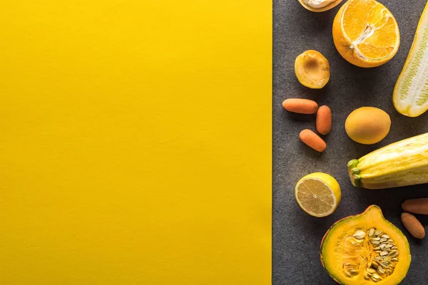 Draufsicht auf Obst und Gemüse auf gelbem und grauem Hintergrund — Stockfoto