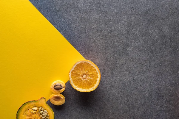 Vista superior de frutas y verduras sobre fondo amarillo y gris - foto de stock