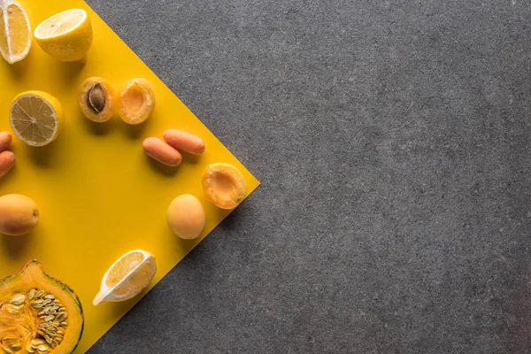 Top view of fruits and vegetables on yellow and grey background — Stock Photo