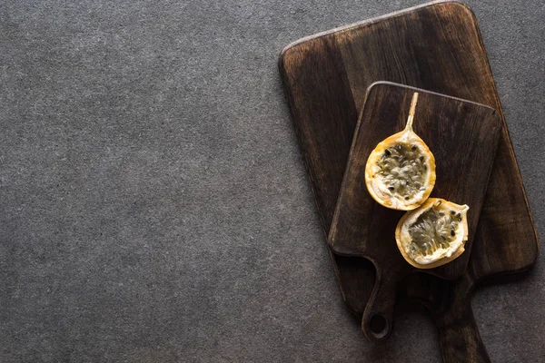 Ansicht von süßem Granadilla auf Holzschneidebrettern auf grauem Hintergrund — Stockfoto