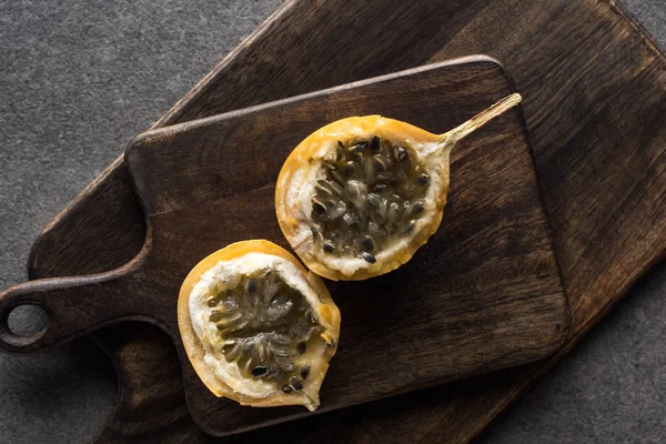 Vista dall'alto di granadilla dolce su taglieri in legno su fondo grigio — Foto stock