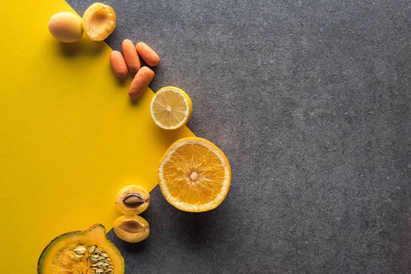 Vista superior de frutas e legumes em fundo amarelo e cinza com espaço de cópia — Fotografia de Stock