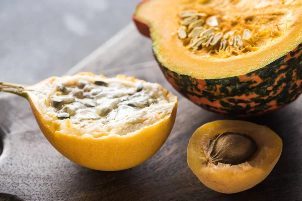 Close up view of yellow sweet granadilla, pumpkin and apricot on wooden chopping boards — Stock Photo