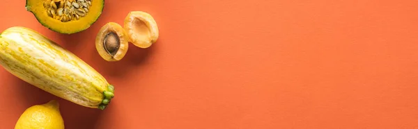 Top view of yellow fruits and vegetables on orange background with copy space, panoramic shot — Stock Photo