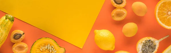 Top view of yellow fruits and vegetables on orange background with copy space, panoramic shot — Stock Photo