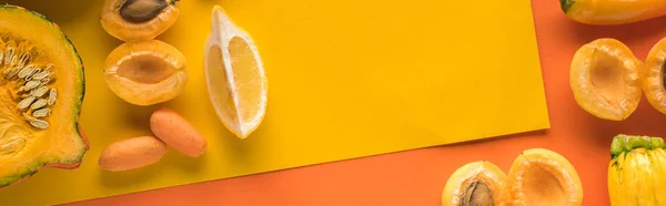 Top view of yellow fruits and vegetables on orange background with copy space, panoramic shot — Stock Photo